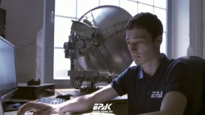 An engineer works on a computer. Antenna in the background.